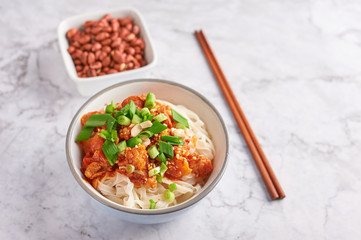 shan noodles with peanuts and chopsticks at white marble tabletop. burmese cuisine traditional...