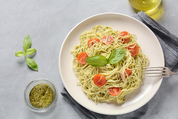 Pasta spaghetti with pesto sauce, fresh basil and cherry tomatoes . Italian traditional food