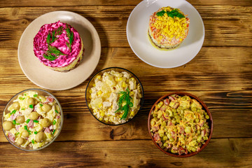 Set of festive mayonnaise salads on wooden table. Top view