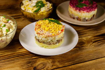 Set of festive mayonnaise salads on wooden table
