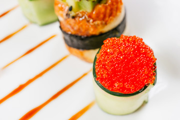 Sushi rolls degustation, fusion food style restaurant menu. Food blog, culinary recipe, food photo art. Set of delicious seafood snacks on white plate