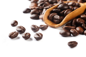 Fototapeta premium A pile roasted of coffee beans with wooden spoon isolated on white background with copy space. 