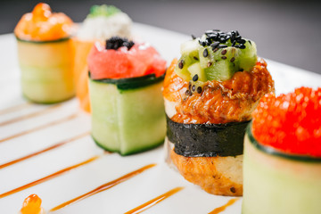Sushi rolls degustation, fusion food style restaurant menu, deluxe gastronomy. Set of finest seafood snacks on white plate