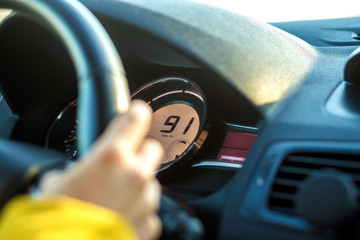 Modern car interior with driver hand on steering wheel. Safe driving concept.