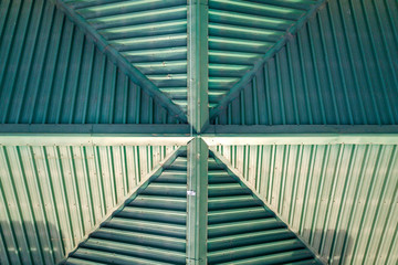 Top aerial view of building green shingle tiled roof construction. Abstract background, geometrical pattern.