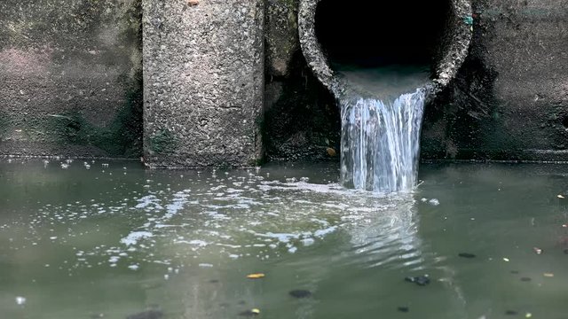 waste water flow to sewer with moss, bad water from city, water pollution, sewer drain pipe dirt sewage water drain to Wastewater Treatment.