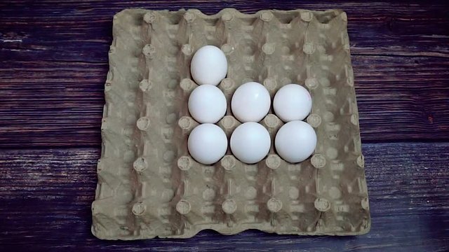 Putting white chickhen eggs in a box