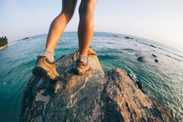 Successful woman walking to the edge on seaside rock cliff
