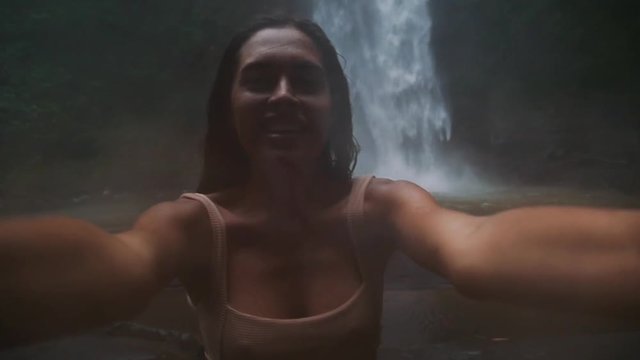 Beautiful girl having fun at the waterfalls in Bali. Concept about wanderlust traveling and wilderness culture
