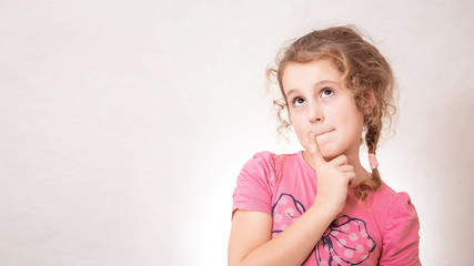 Fototapeta premium Cute girl eight years old with Curly hair on gray background