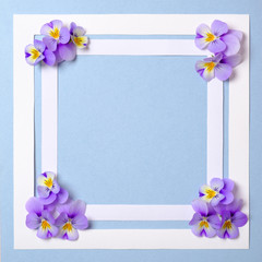 Flat lay square frame with flower petals on watercolor spring background. Top view, floral frame, abstract design. Invitation, greeting card or an element for your design.