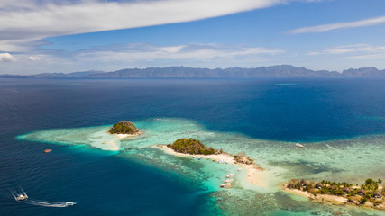 Seascape bay with turquoise water and coral reef and beach. Tropical island with white beach. Bulog Dos, Philippines, Palawan aerial view