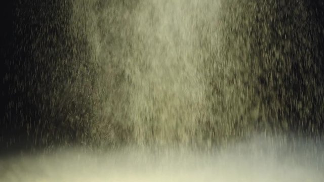 slow motion shoot of two cosmetic brushes touching and making splash of yellow holi paint and then powder falling slowly down