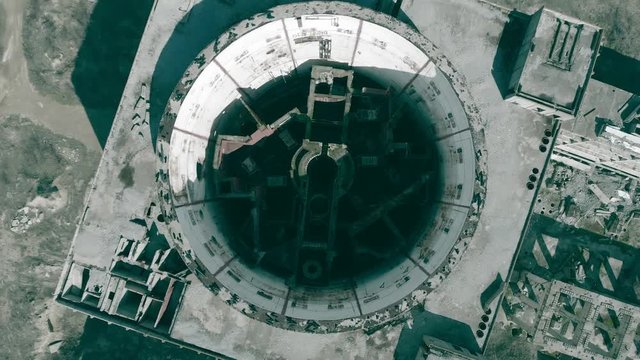 Round hole of atomic reactor in abandoned ruined Nuclear Power Plant. Aerial top view from drone with circle and up motion of of large destroyed industrial building