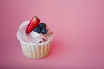 Sweet dessert on pink background, copy space. Cupcake with cream, beautiful and delicious.
