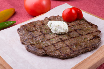 Fried horse meat steak served on wooden board