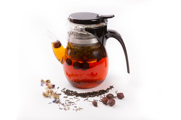 Glass transparent teapot on white backgrounf with tea ingredients