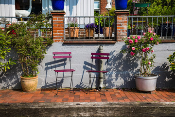 Fototapeta na wymiar Romantischer Ruheplatz mit 2 Stühlen und blühenden Büschen