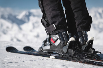 Close-up of the athlete's skier's foot in ski boots rises into the skis against the background of...