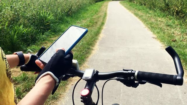Female Cyclist Holding a Smart Phone Searching for a Route