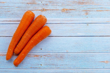 Top view of carrot on wooden background. Copy space for text or logo.