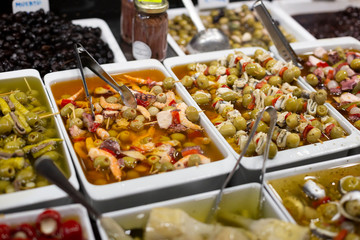 Big green fresh ripe olives on sticks with different stuffing seafood, meat, red pepper, and others. Traditional snacks and tapas