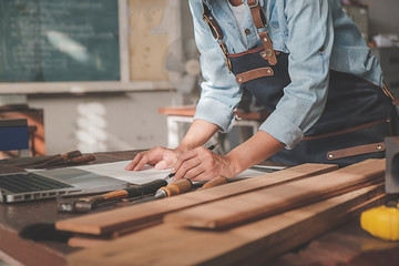 Carpenter working with equipment on wooden table in carpentry shop. woman works in a carpentry shop.