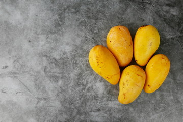Top view of Chok Anan or Chocanon mango on grey,black and white floor. Copy space for text or logo.