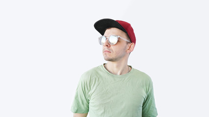 young guy in sunglasses t-shirt smiling while standing against white background portrait, close up          