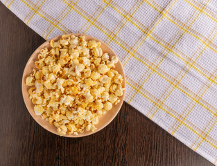 A plate of popcorn and a napkin on the table.