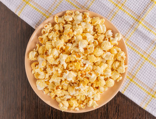 A plate of popcorn and a napkin on the table.