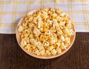 A plate of popcorn and a napkin on the table.