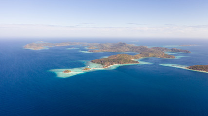 aerial view tropical islands with blue lagoon, coral reef and sandy beach. Palawan, Philippines. Islands of the Malayan archipelago with turquoise lagoons.