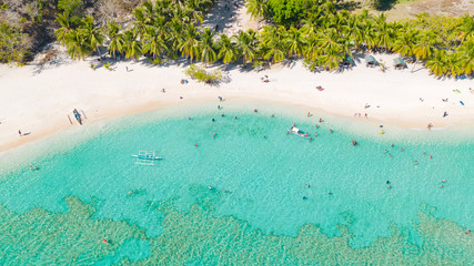 Tourists relax on the white beach. Tropical island and azure seaaerial view