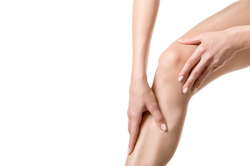 Human injured knee joint. Person touches a sore spot on leg by hands. Well groomed skin, close up,...