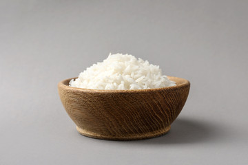 Bowl of tasty cooked rice on grey background