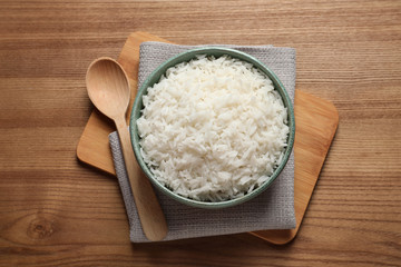 Bowl of tasty cooked rice served on table, flat lay
