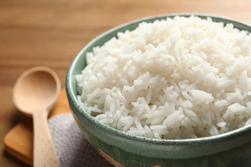 Bowl of tasty cooked rice served on table, closeup