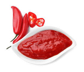 Gravy boat with red sauce and fresh chili peppers isolated on white, top view