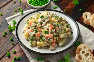 Russian traditional salad Olivier with vegetables and meat.