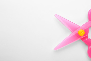 Colorful plastic scissors on white background. School stationery