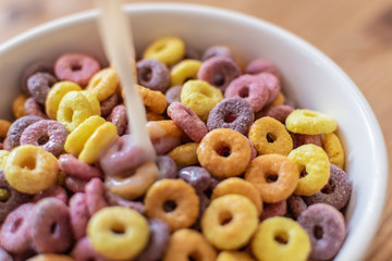 Cuenco de Cereales de colores y leche cayendo
