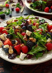 Fresh Fruit Salad with blueberry, strawberry raspberry, walnuts, feta cheese and green vegetables. healthy summer food