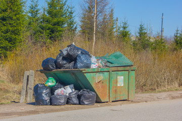 Garbage bin with trash bags. A whole container of garbage near the road.