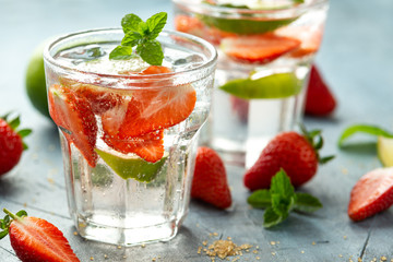 Strawberry Mojito cocktail with Rum, lime and mint in glass. Summer cold drink with ice