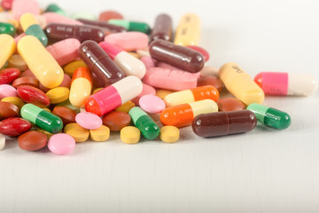 Colorful pills splatter on white background.The different tablets and capsule heap mix therapy drugs.