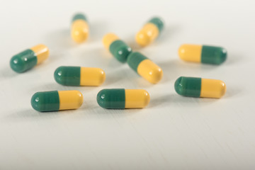 Green, yellow tramadol capsule pills on white background.Pain killer capsules called "Tramadol HCL".The medicine for pain relive.