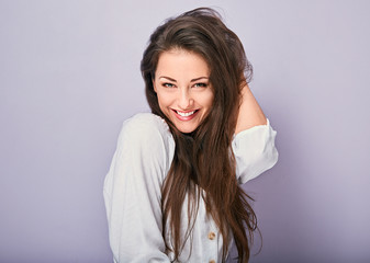 Fototapeta premium Beautiful excited toothy smiling woman looking with happy in white shirt with long curly hairstyle. Closeup portrait