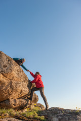 Two mans help each other hiking