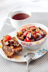 Vegetable stew with eggplant, red pepper and tomatoes on toasted rye bread